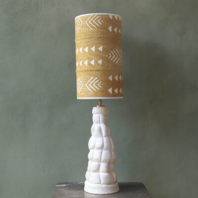 Lamp base with a mud cloth lampshade. Base in mat white finish.