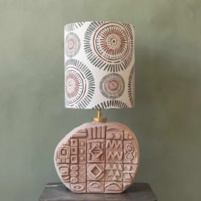 ceramic round lampbase with african symbols on it. In