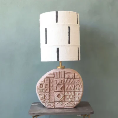 lamp base of ceramic in terra colour with tiles in true symbols. Mudcloth lampshade white with black stripe