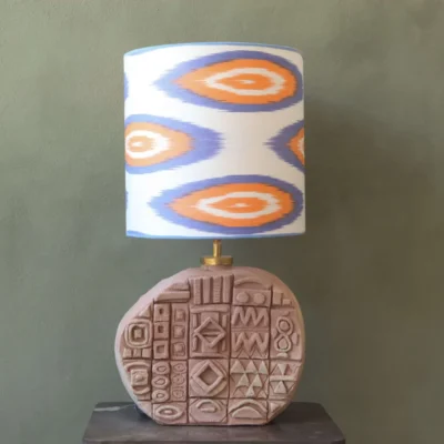 Lampbase of ceramic with African symbols. Ikat lampshade in blue and orange.