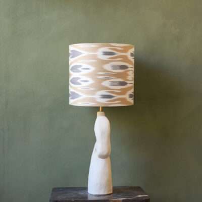 Lamp base of ceramic, white, unglazed, organic and curves form with a beige Ikat lampshade