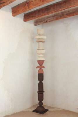 Totem of ceramic, made of different pieces like stones in the colours black, red and white.
